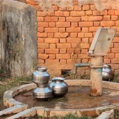 Silver pots next to an outdoor water well