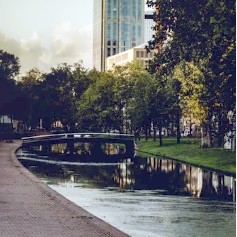 River flowing through inner city surrounded by tress and high-rise buildings 