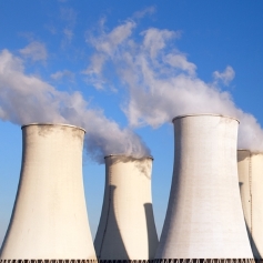 power station emitting white smoke into the sky 