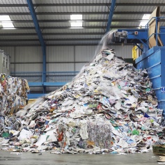 large pile of recycled rubbish coming from a machine at recycling plant 