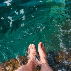 Dipping feet into vibrant turquoise sea