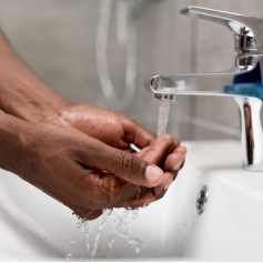 Washing hands under running water from a tap