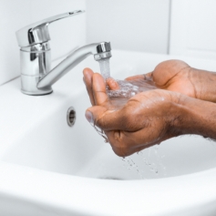 man washing hands under running water