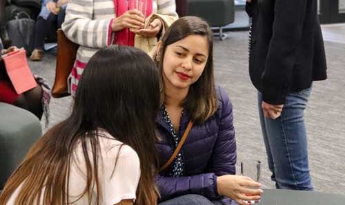 Two women sitting chatting at a conference 