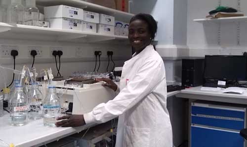 Cecilia Medupin in a lab coat working in a laboratory