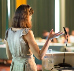 A woman giving a speech at a conference 
